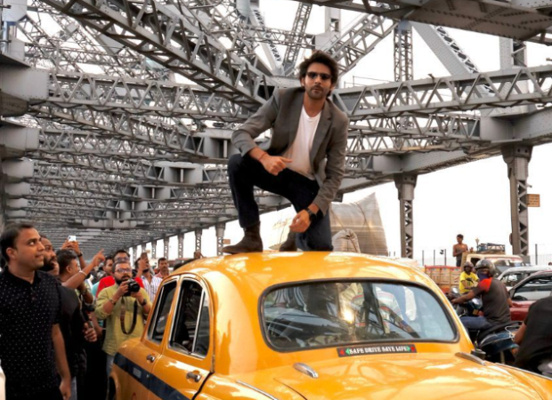 Bhool Bhulaiyaa 2: Kartik Aaryan poses on the roof of Kolkata's famous yellow taxi at Howrah bridge, celebrates Rs. 100 cr success amidst 'Amije Tomar' song launch