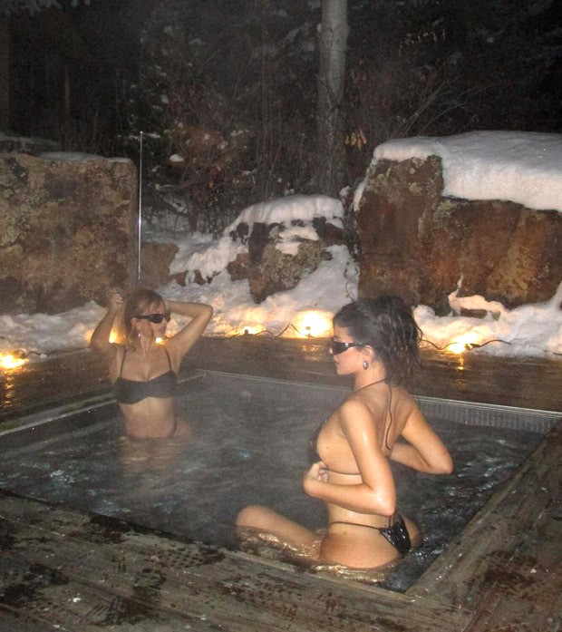 Kylie Jenner lounges with a friend in a hot tub at midnight while donning a tiny black bikini in Aspen's frigid weather