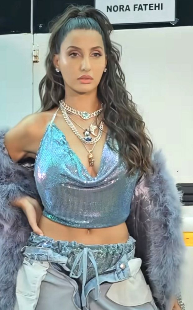 Nora Fatehi in a shiny chainmail top and inside out denim jeans is